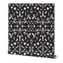 A roll of abstract wallpaper featuring a geometric pattern with black shapes on a white background.