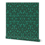 A roll of abstract wallpaper featuring a geometric pattern with jade green shapes on a light green background.
