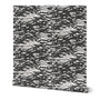 A roll of peel-and-stick wallpaper featuring a black on white, abstract coastal wave pattern.