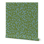 A roll of wallpaper featuring a hand-painted botanical leaf pattern with teal and green hues.