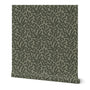 A roll of wallpaper with a hand-painted floral, climbing vine design in a sage green color.