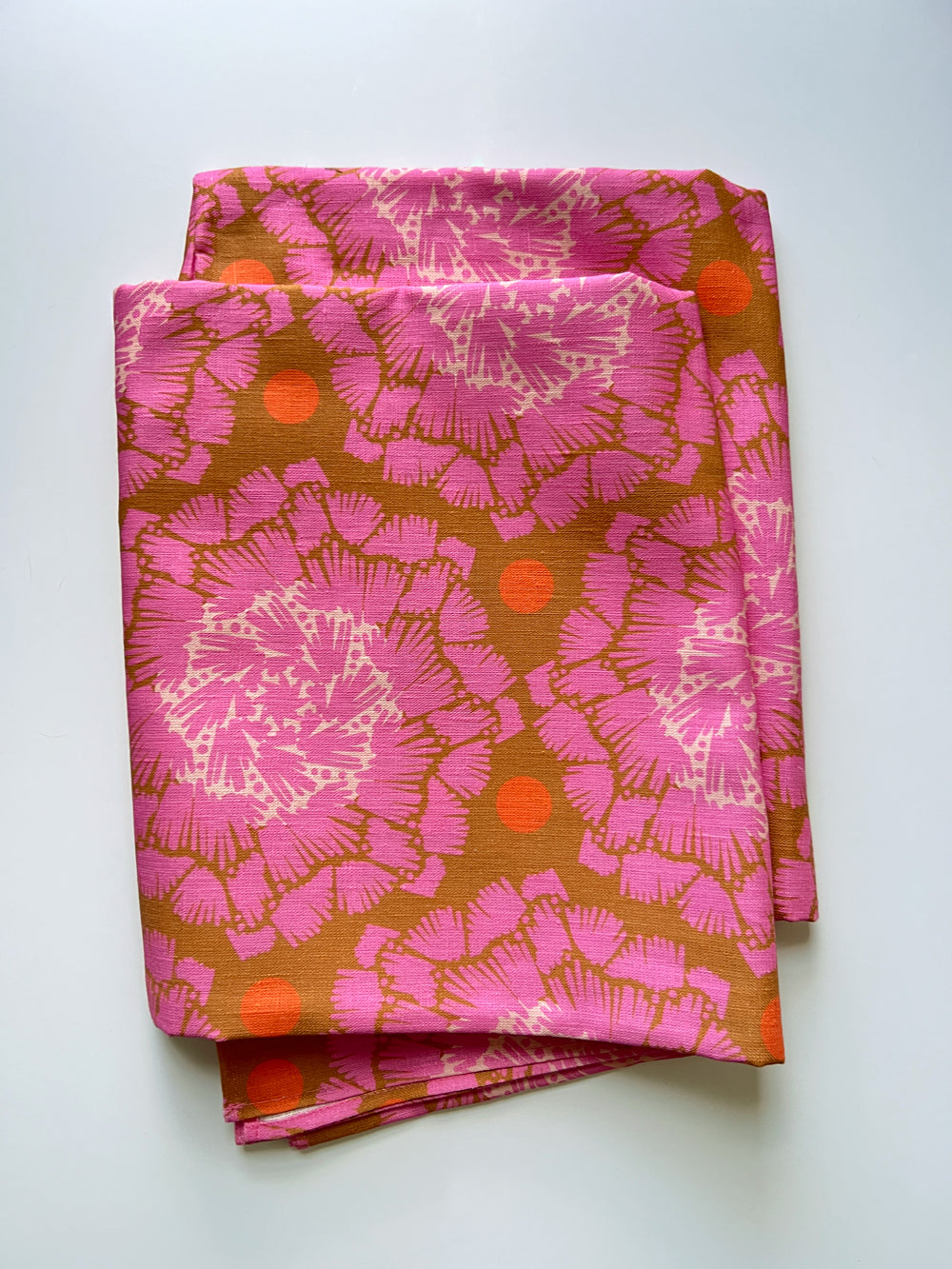 Pink and brown patterned tablecloth on a white background