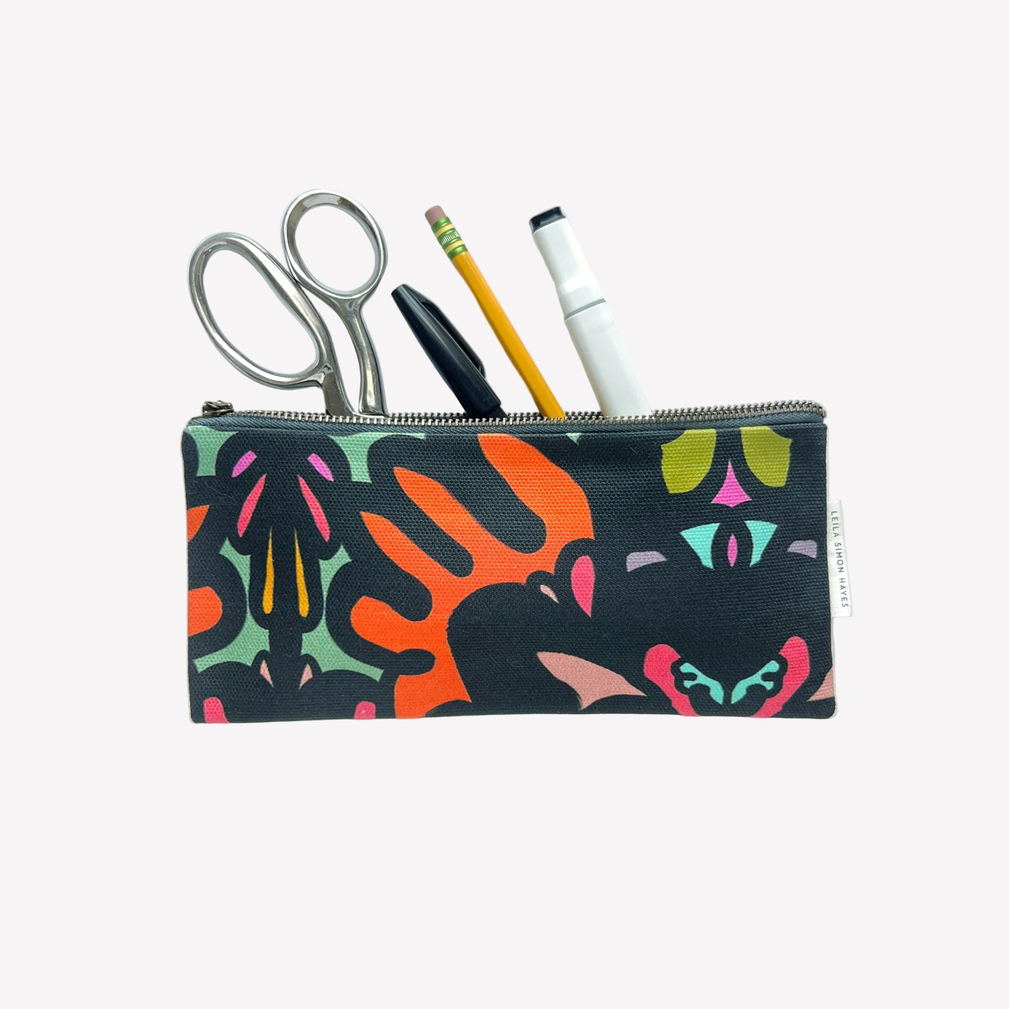 Colorful patterned pouch with stationery items on a white background