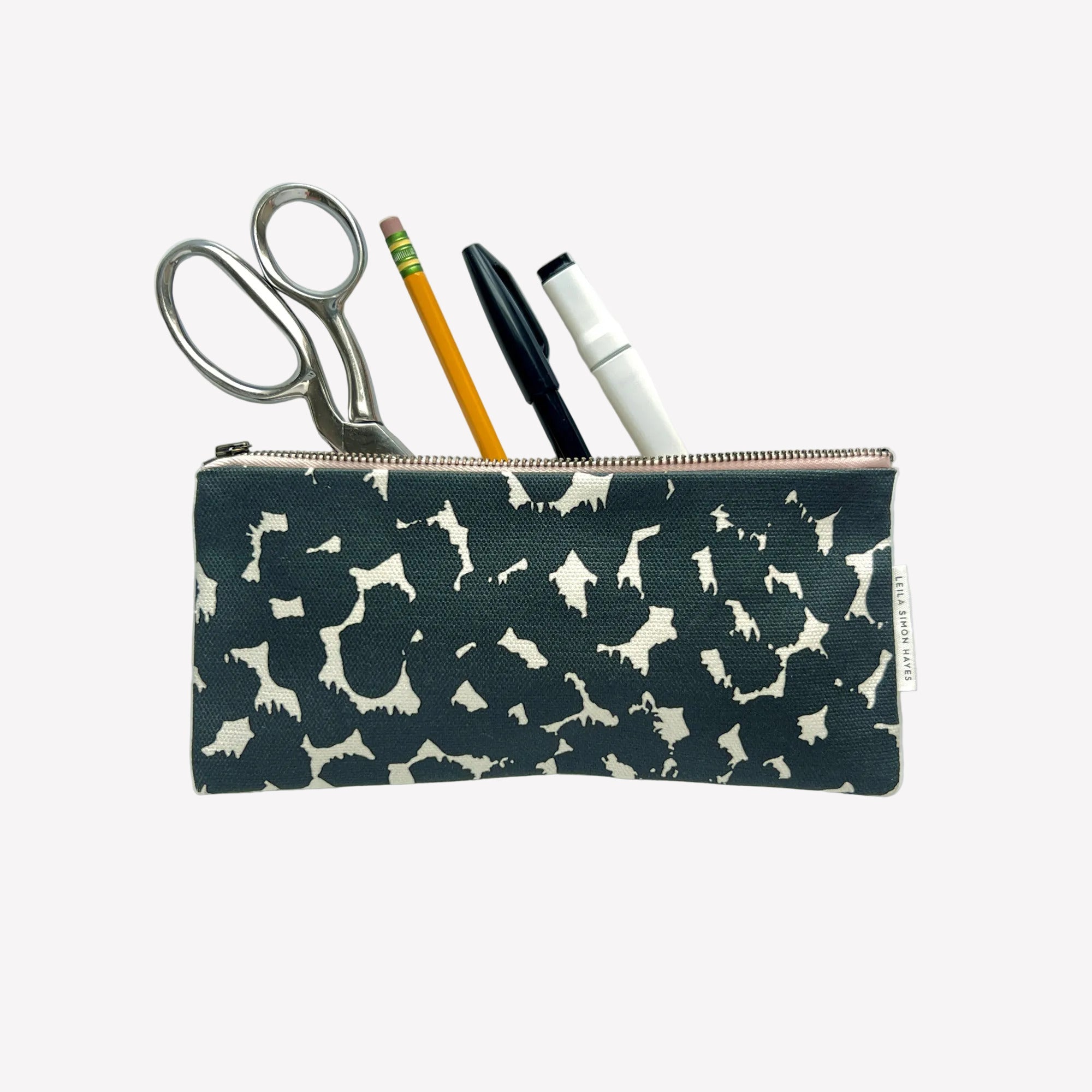 Pencil case with abstract dot pattern containing scissors, pencil, and markers on a white background