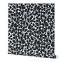 A roll of wallpaper featuring a hand-painted botanical leaf pattern in black and a white base. Designed by artist Leila Simon Hayes.
