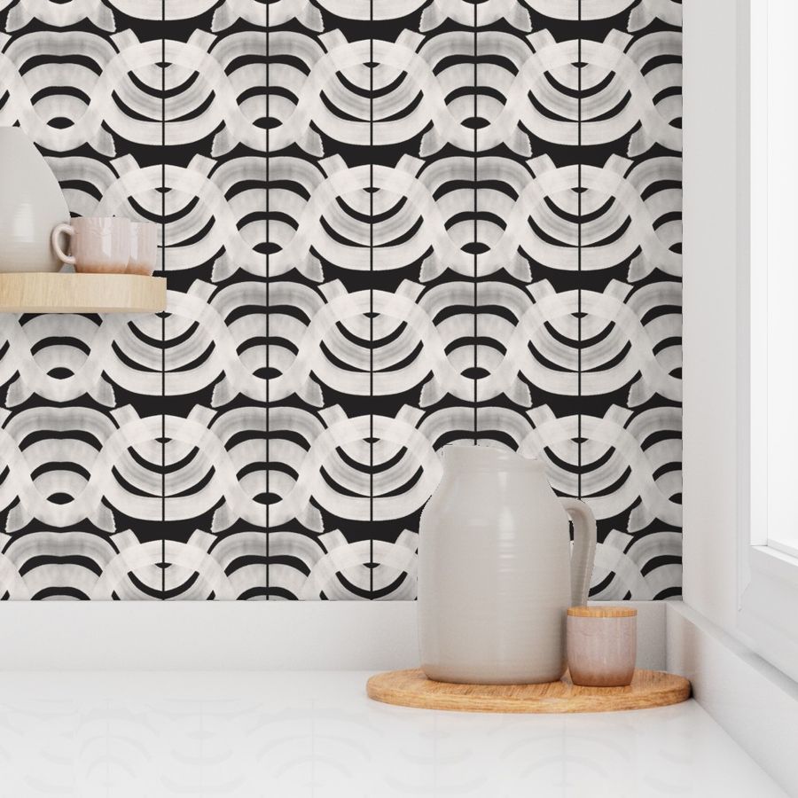 A section of white wallpaper with a geometric pattern of hand-painted designs in a home environment, featuring a matte finish and adhered to a wall with a grey jug and a wooden tray. Designed by artist Leila Simon Hayes.