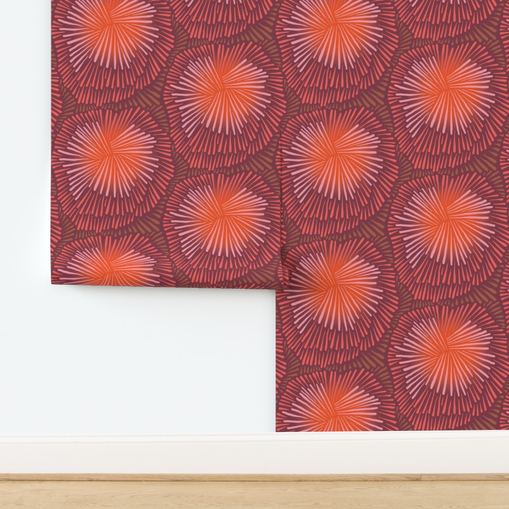 Roll of wallpaper with a red and orange patterned paper on a white background. Designed by artist Leila Simon Hayes.