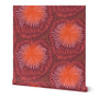 A roll of peel-and-stick wallpaper unraveled, with a white background. The abstract wallpaper design has large pink and red firework floral designs. Designed by artist Leila Simon Hayes.