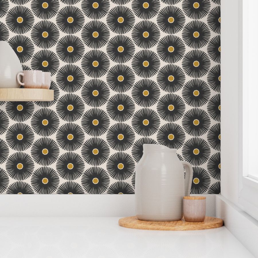 A kitchen backsplash with black and white floral patterned wallpaper, featuring a geometric design with yellow centers, decorated with a ceramic jug and bowl on a wooden surface. Designed by artist Leila Simon Hayes.