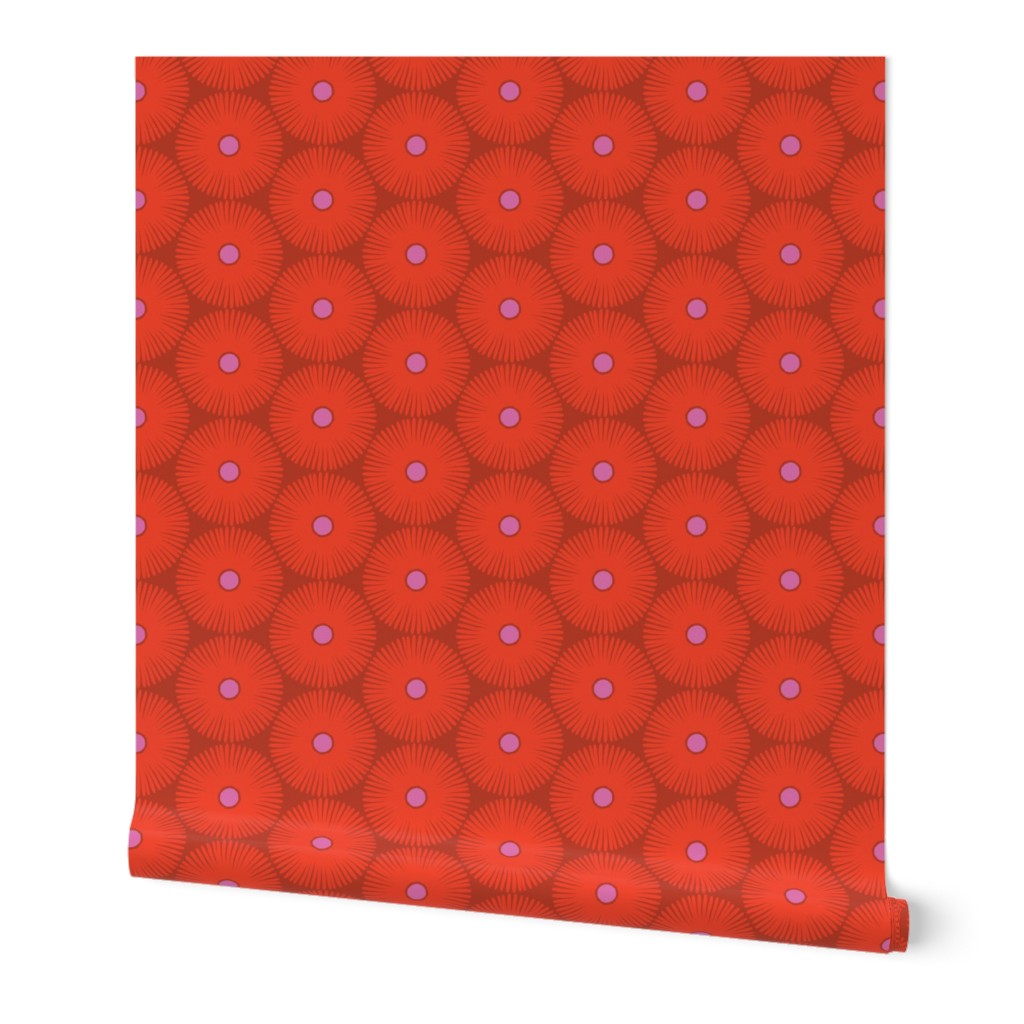 Roll of wallpaper with red patterned floral circular designs and a pink center, on a dark red base. Designed by artist Leila Simon Hayes.