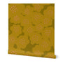 A roll of yellow wallpaper with a hand-painted abstract floral design including abstract yellow flowers with peach dotted centers, slightly overlapping. Designed by artist Leila Simon Hayes.