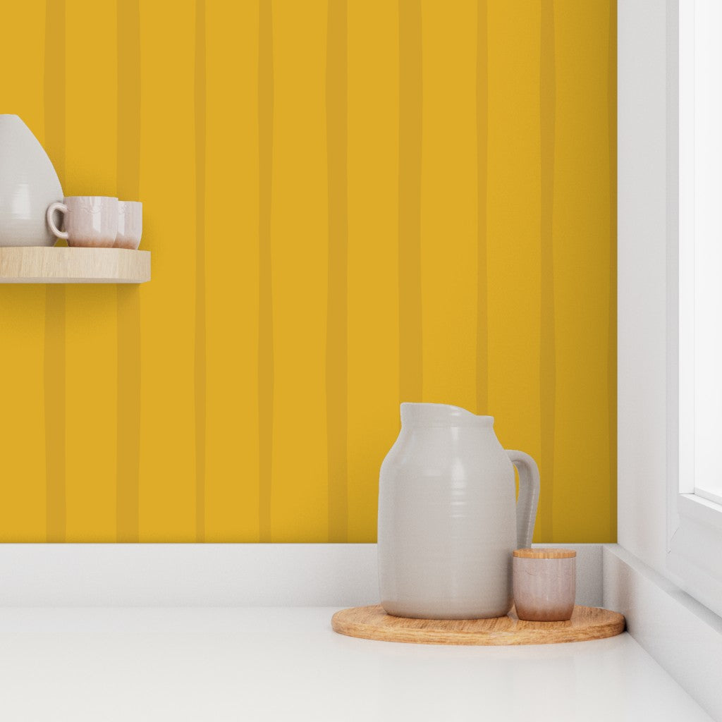 White ceramic pitcher and cups on a wooden tray against a yellow striped wall. Designed by artist Leila Simon Hayes.