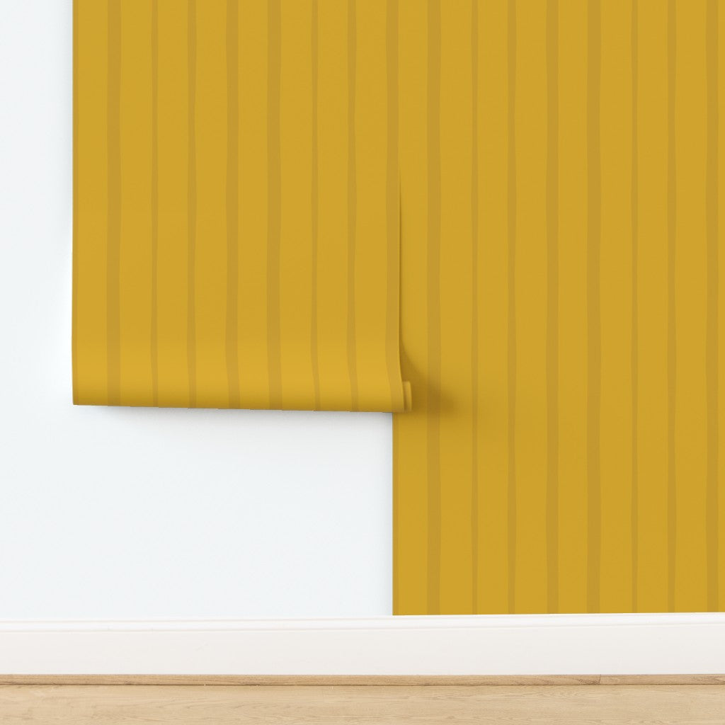 Mustard yellow wallpaper with vertical stripes on a white background. Designed by artist Leila Simon Hayes.