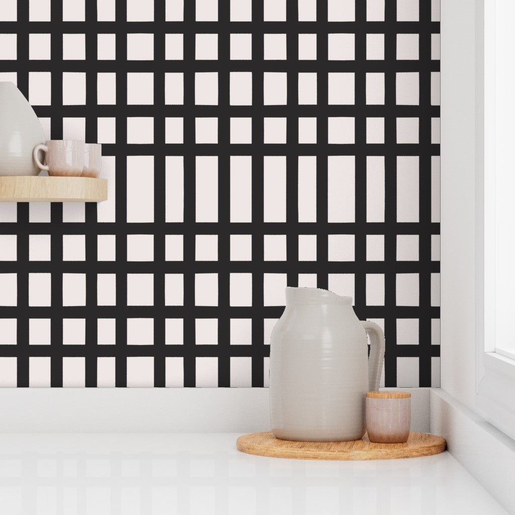Kitchen scene with a black and white grid pattern wall, ceramic pitcher, and small container on a wooden board. Designed by artist Leila Simon Hayes. 
