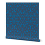 A roll of abstract wallpaper featuring a geometric pattern with dark blue shapes on a bright blue background. Designed by artist Leila Simon Hayes.