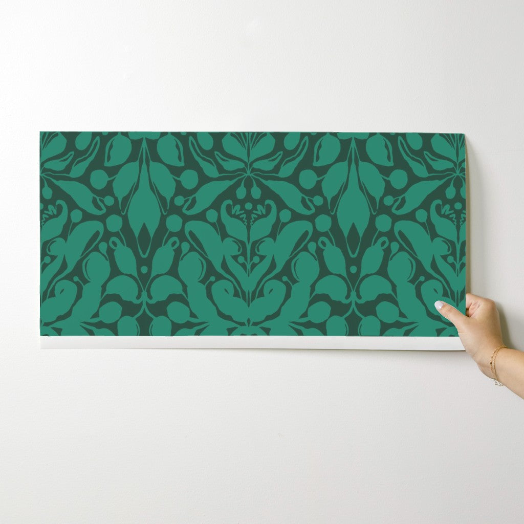 Green patterned box being held by a hand on a white background. Designed by artist Leila Simon Hayes.