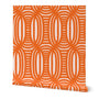Roll of peel-and-stick geometrical wallpaper on a white background. The wallpaper has a dark orange, wavy and intersecting, weave pattern over light peach base. Designed by artist Leila Simon Hayes.