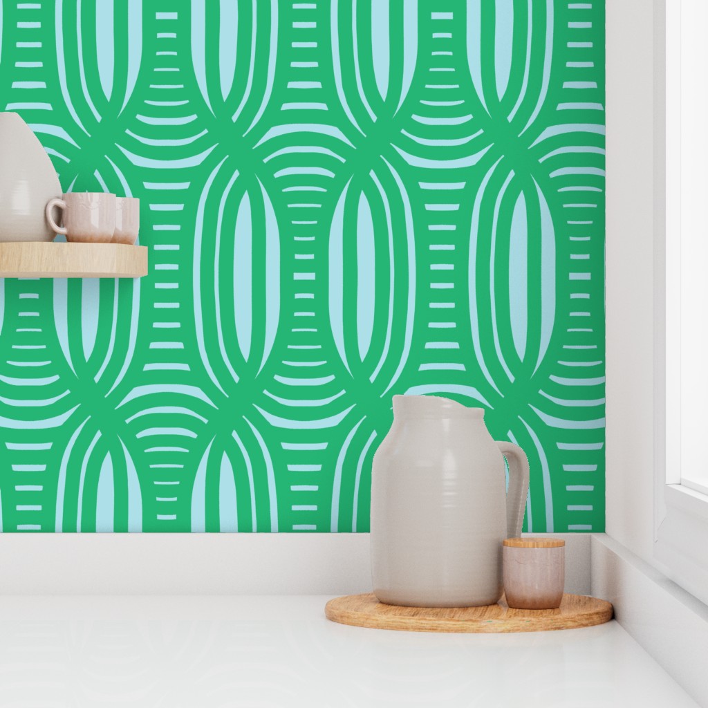 Green and light blue geometric patterned wallpaper with ceramic pitcher and cups on a shelf. Designed by artist Leila Simon Hayes.