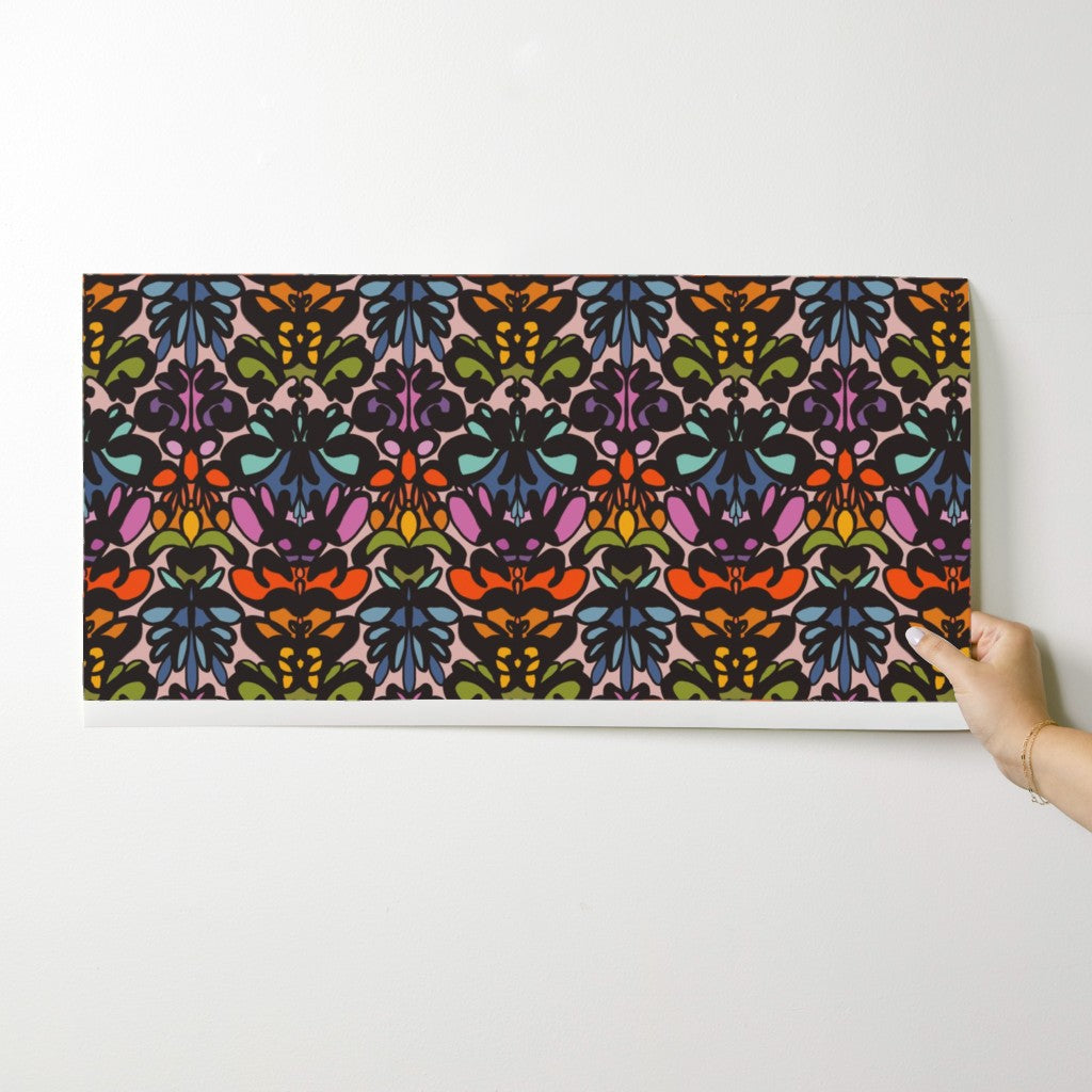 Hand holding a colorful wallpaper swatch against a white background. Designed by artist Leila Simon Hayes. 