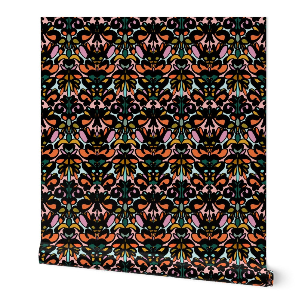 Roll of peel-and-stick wallpaper on a white background. The wallpaper is a colorful kaleidoscope pattern on a black base. Designed by artist Leila Simon Hayes. 