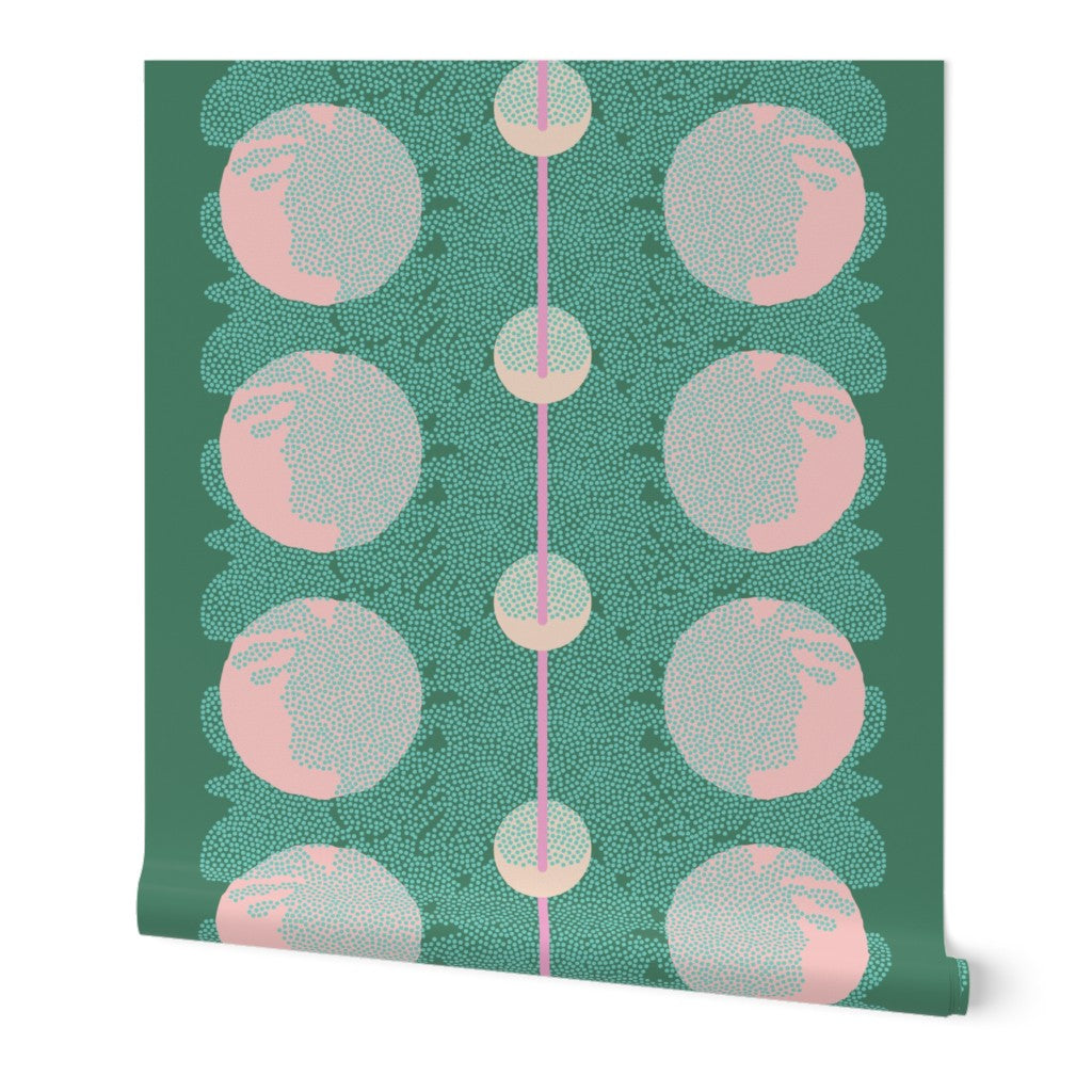 Roll of wallpaper with an abstract pattern of pink circles and neon blue dots overlapping and a pink stripe down the middle, on a green base. Designed by artist Leila Simon Hayes.