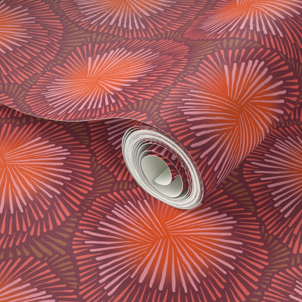 Roll of fabric with a red and orange sun burst pattern. Designed by artist Leila Simon Hayes.