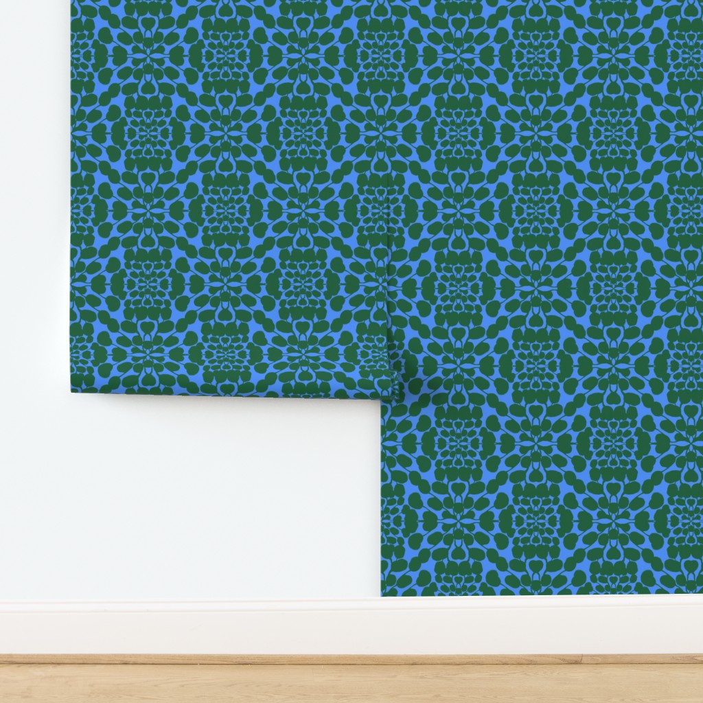 Roll of green and blue patterned wallpaper on a white background. Designed by artist Leila Simon Hayes.