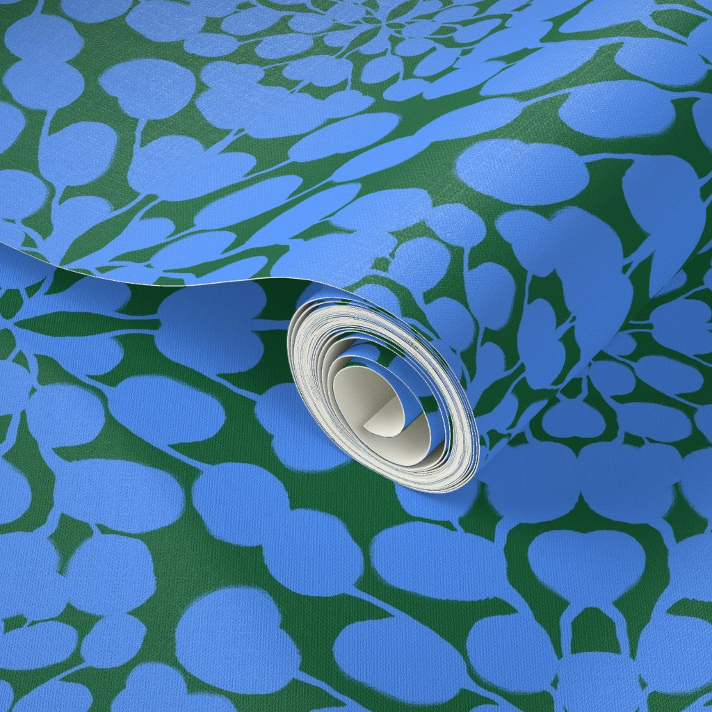 Roll of blue floral patterned paper on a green background. Designed by artist Leila Simon Hayes.