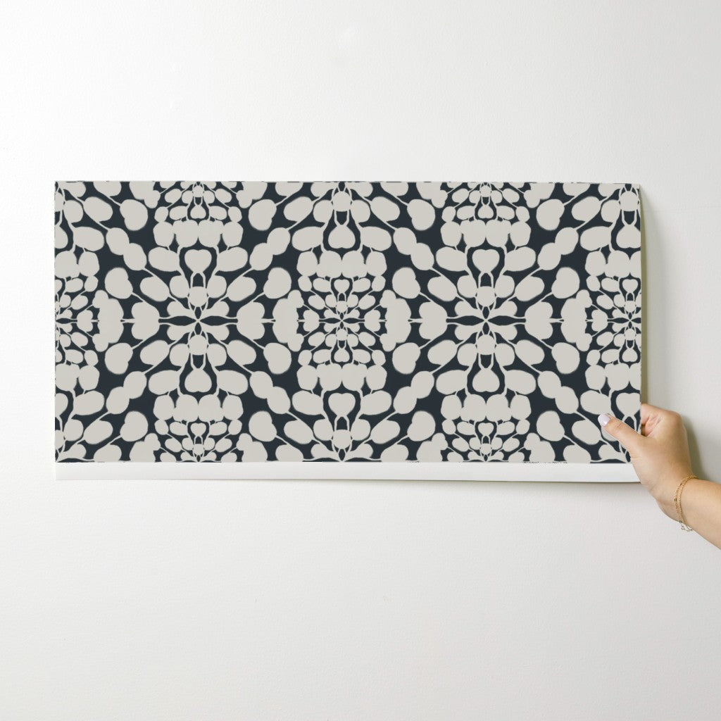 Person holding a wallpaper swatch  with a white hand on a white background. Designed by artist Leila Simon Hayes. 