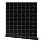 Roll of wallpaper with black abstract pattern and orange dots on a white background. Designed by artist Leila Simon Hayes.