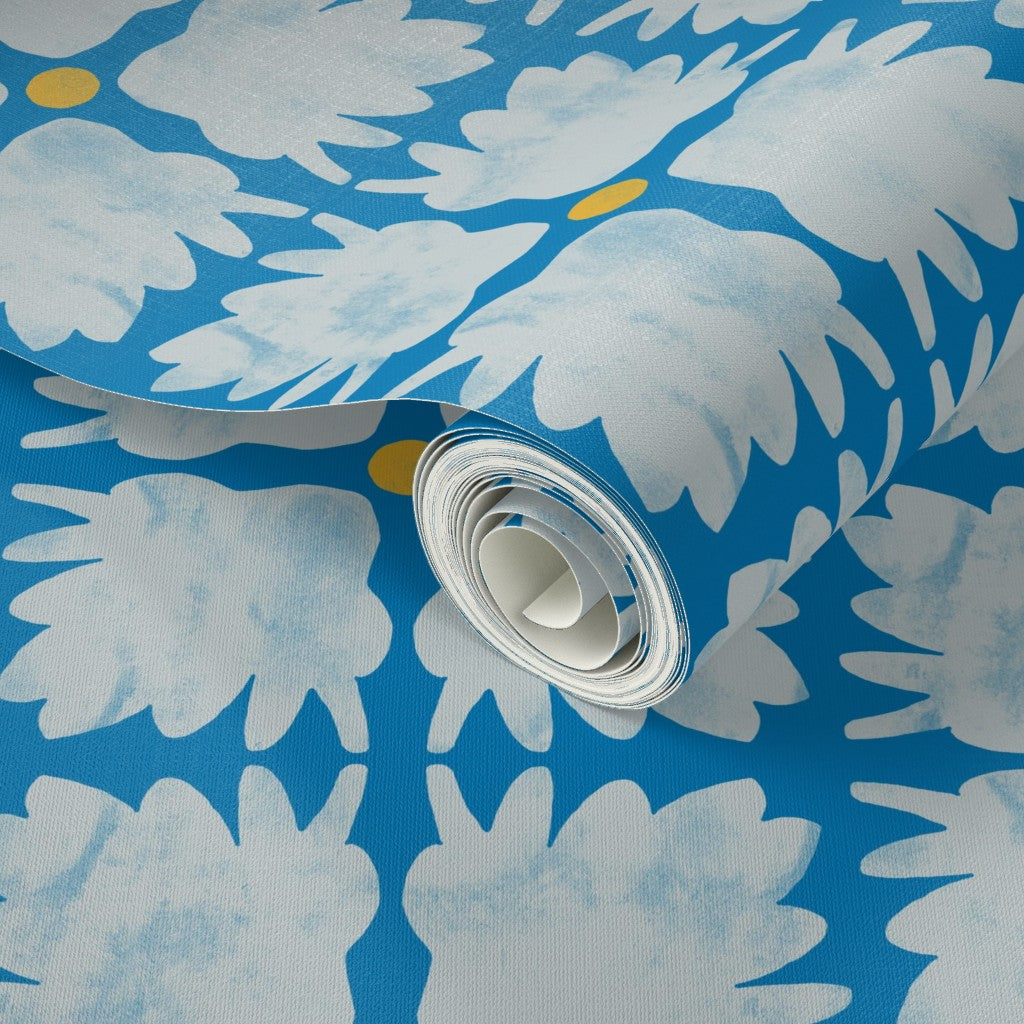 Roll of wallpaper with white floral design on a blue background. Designed by artist Leila Simon Hayes.