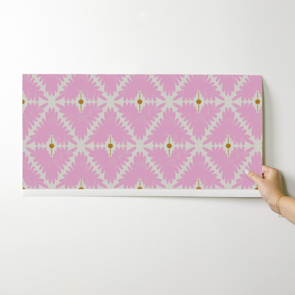 Pink and white patterned mat held by a hand on a white background. Designed by artist Leila Simon Hayes.