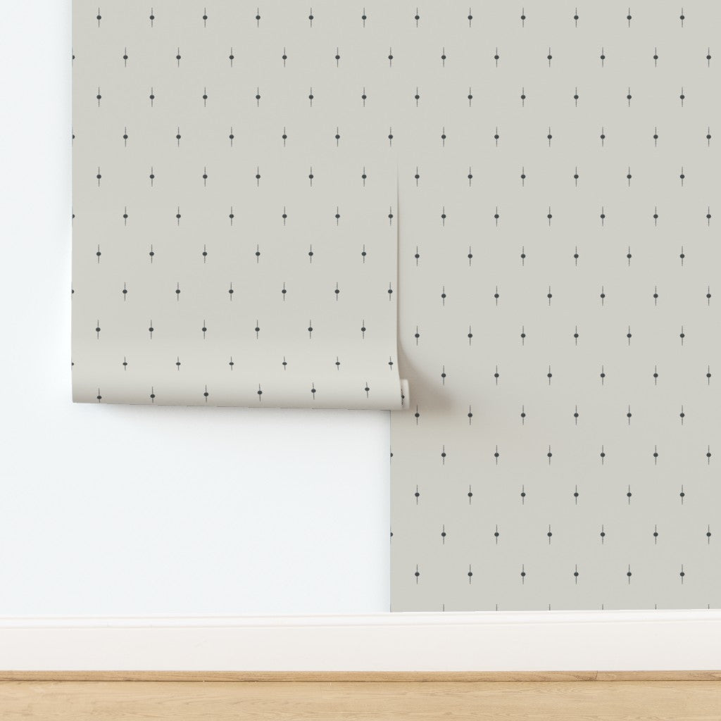A roll of white wallpaper with subtle black geometric star pattern. Designed by artist Leila Simon Hayes. 
