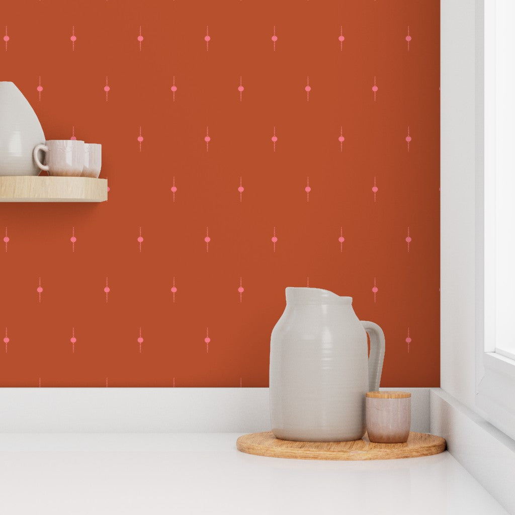 White ceramic pitcher and small cup on a wooden tray against a burnt orange wall with pink geometric star pattern. Designed by artist Leila Simon Hayes. 