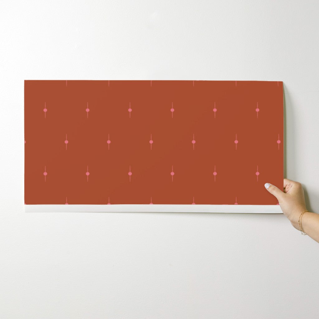 Rectangular wallpaper swatch held by a hand on a white background. Designed by artist Leila Simon Hayes. 
