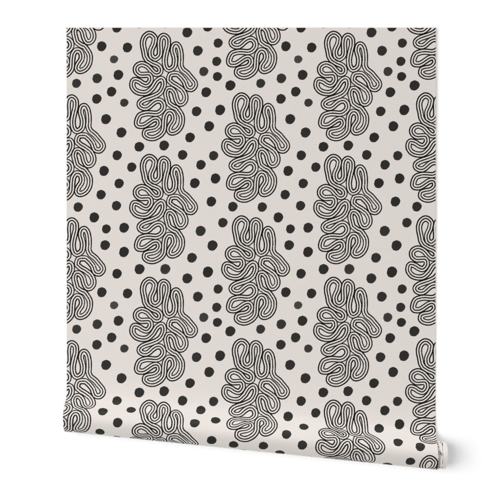Patterned roll of wallpaper with black and white dots and loops design on a white background. Designed by artist Leila Simon Hayes. 
