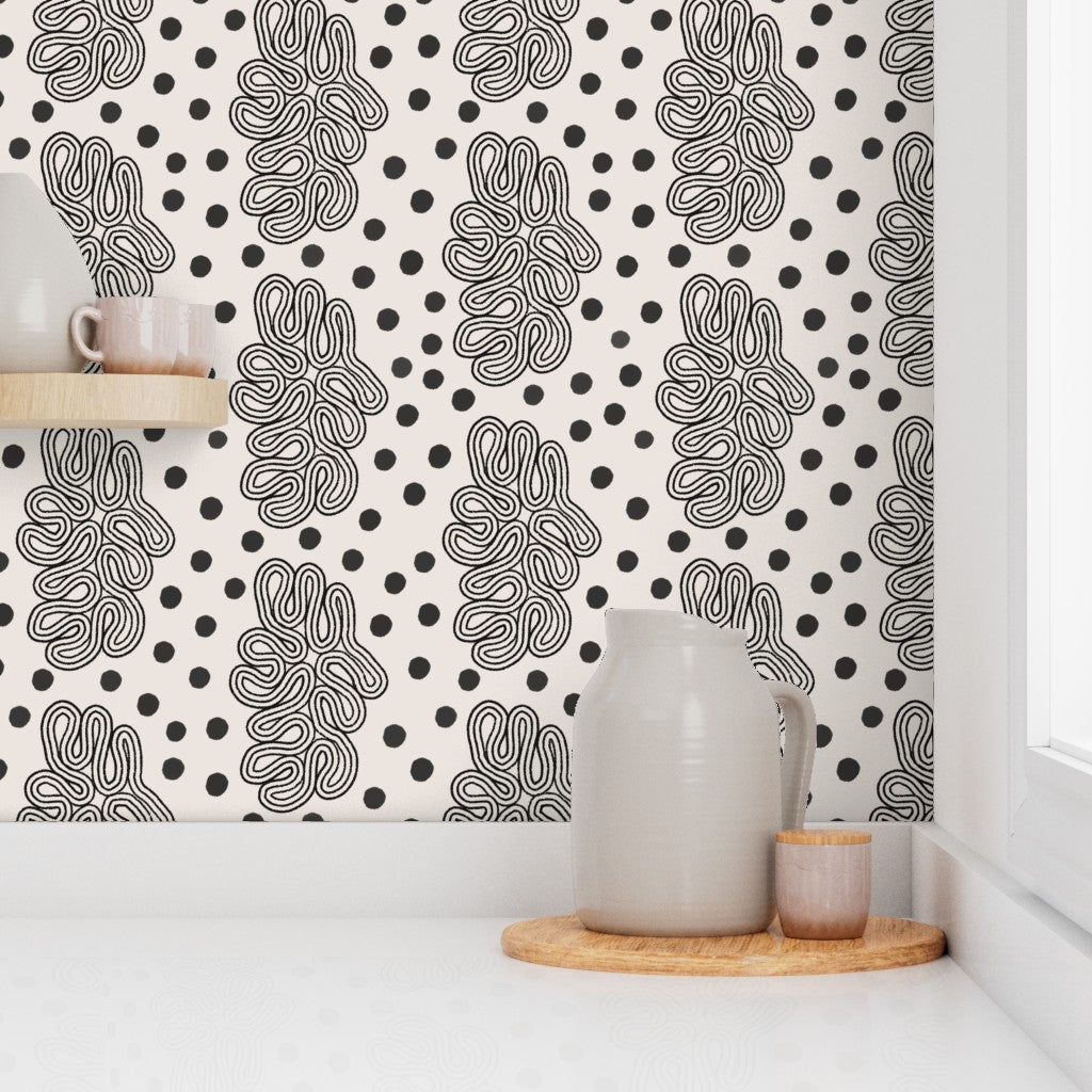 Room interior with a black and white patterned wall, a ceramic pitcher, and a wooden tray. Designed by artist Leila Simon Hayes. 