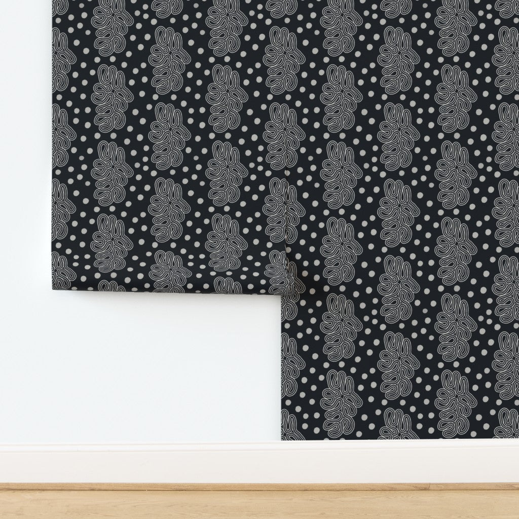 Patterned black and white wallpaper with geometric loops design on a white background. Designed by artist Leila Simon Hayes. 