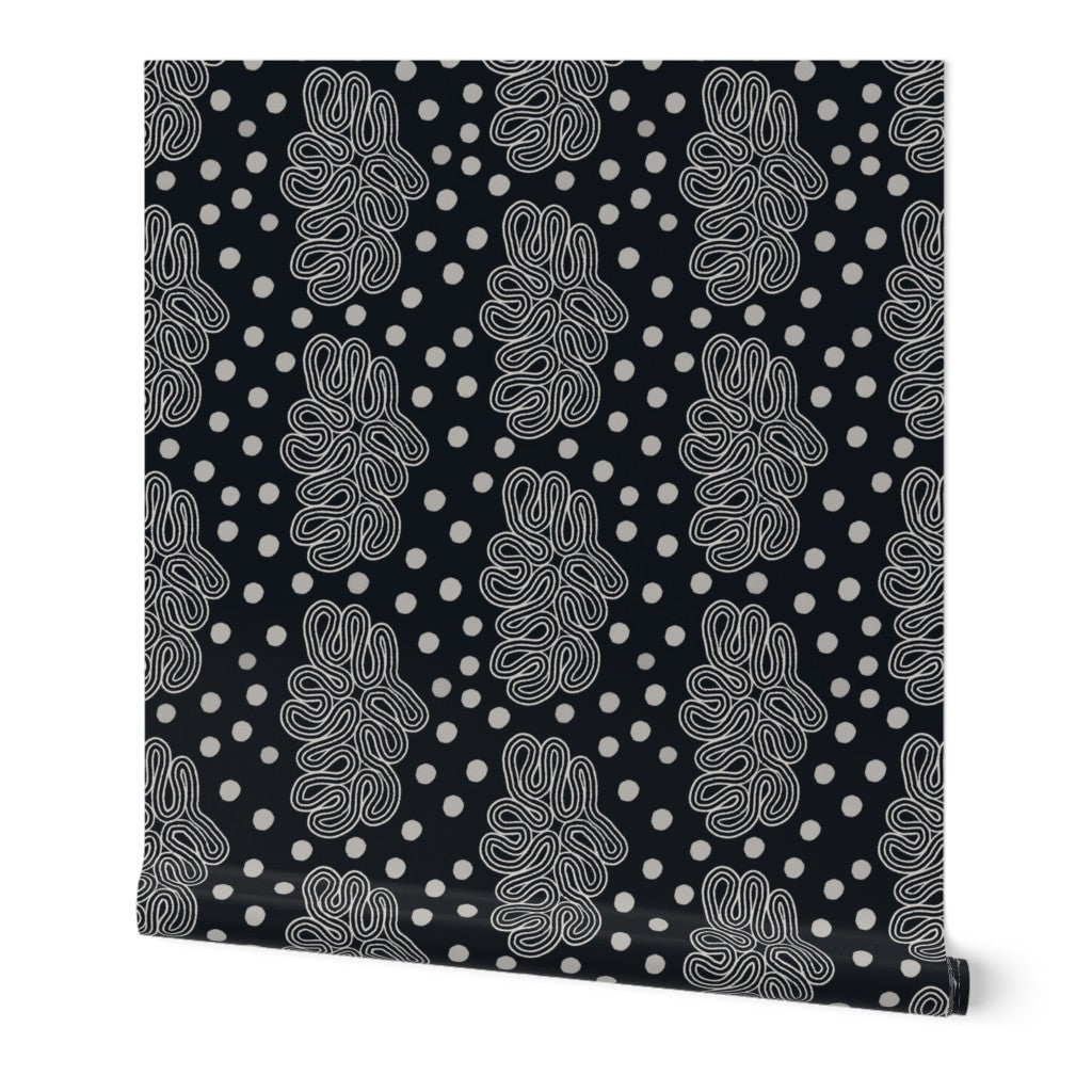 Black and white roll of wallpaper with white abstract loop pattern. Designed by artist Leila Simon Hayes. 