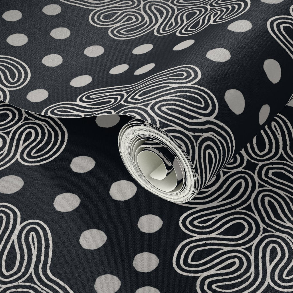 Roll of black and white wallpaper with white polka dots and wavy loop lines. Designed by artist Leila Simon Hayes. 