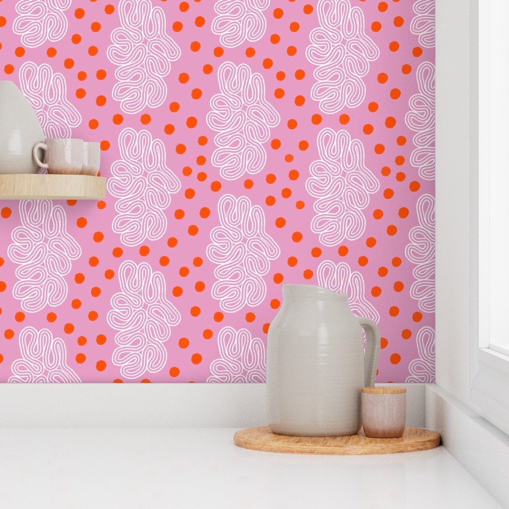 Decorative wallpaper with pink background, white abstract patterns, and red dots in a room with a vase and small container on a shelf. Designed by artist Leila Simon Hayes. 