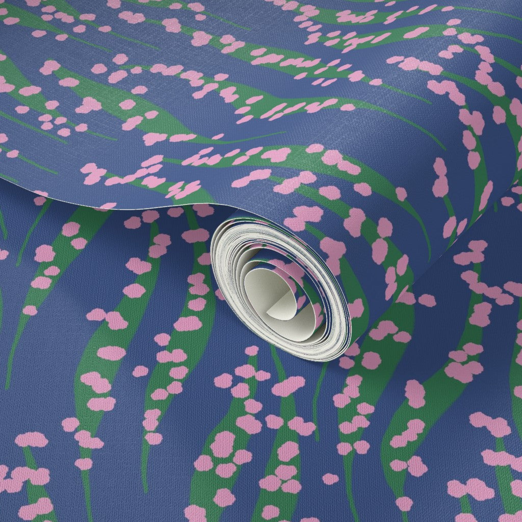 Roll of wallpaper with pink floral pattern on a blue background. Designed by Leila Simon Hayes. 