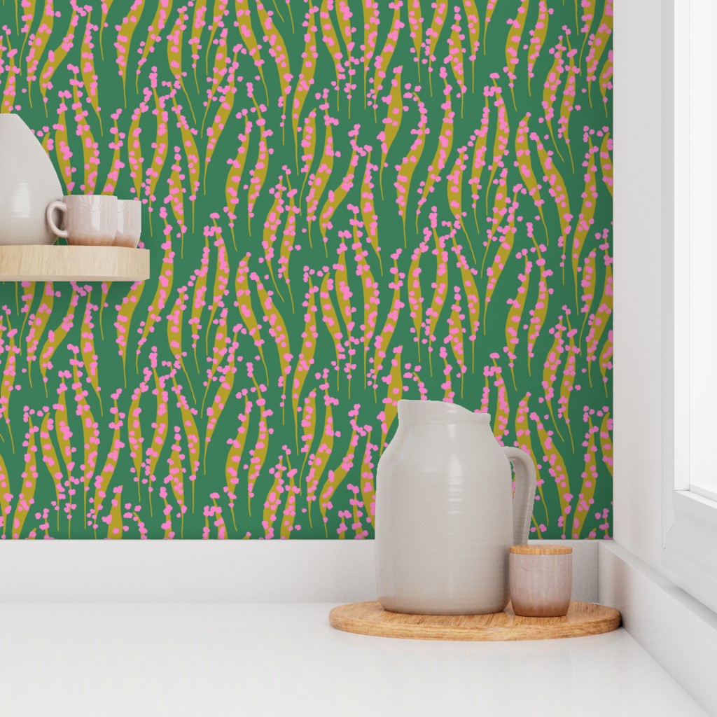Room interior with a green wall featuring a colorful pattern, white pitcher, and wooden tray. Designed by artist Leila Simon Hayes.