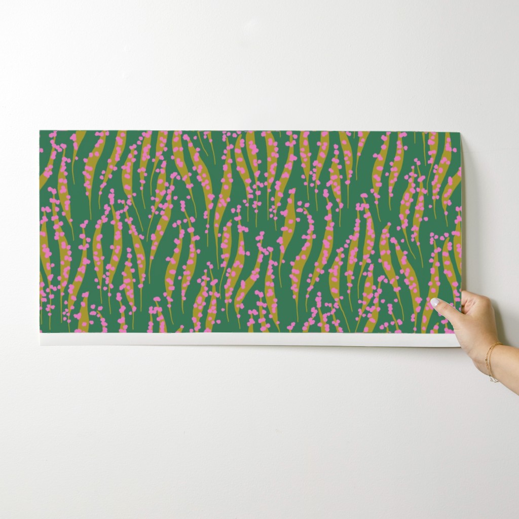 Hand holding a wallpaper swatch with pink and yellow abstract pattern on a white background. Designed by artist Leila Simon Hayes. 