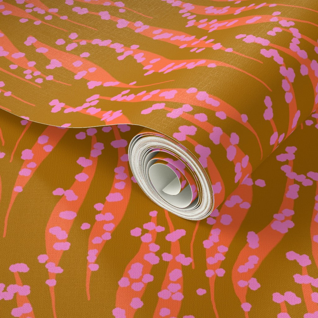 Roll of wallpaper with pink and orange abstract pattern on a brown background. Designed by artist Leila Simon Hayes. 
