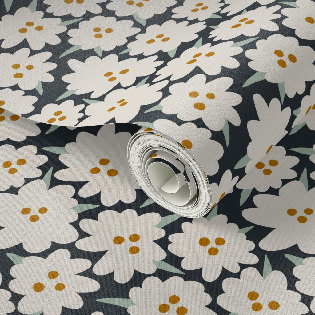 Roll of floral wallpaper with white flowers and yellow centers on a dark background. Designed by artist Leila Simon Hayes.