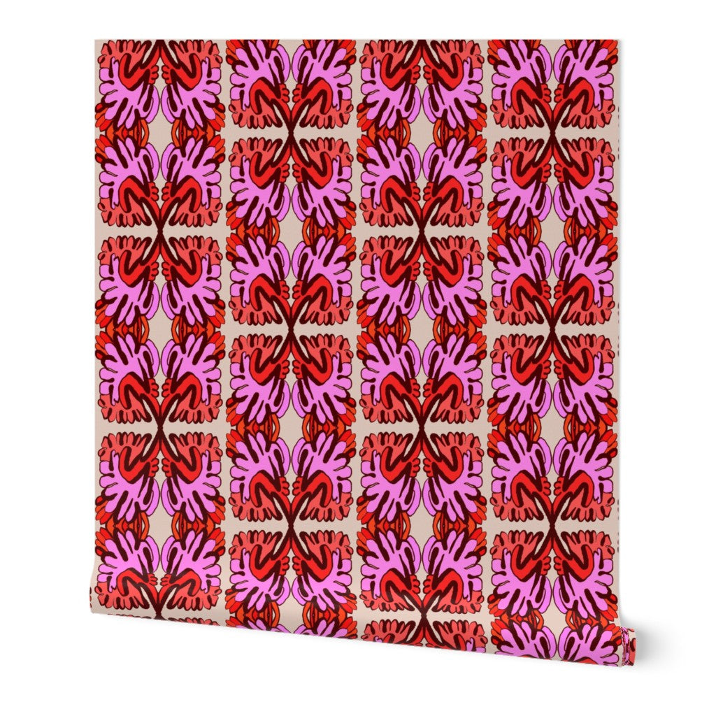 Roll of wallpaper with a red and pink geometric pattern on a white background. Designed by artist Leila Simon Hayes.