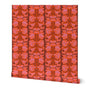 A roll of wallpaper featuring a vertical damask pattern in vibrant shades of red, orange, and pink, shown against a plain white background. Designed by artist Leila Simon Hayes.