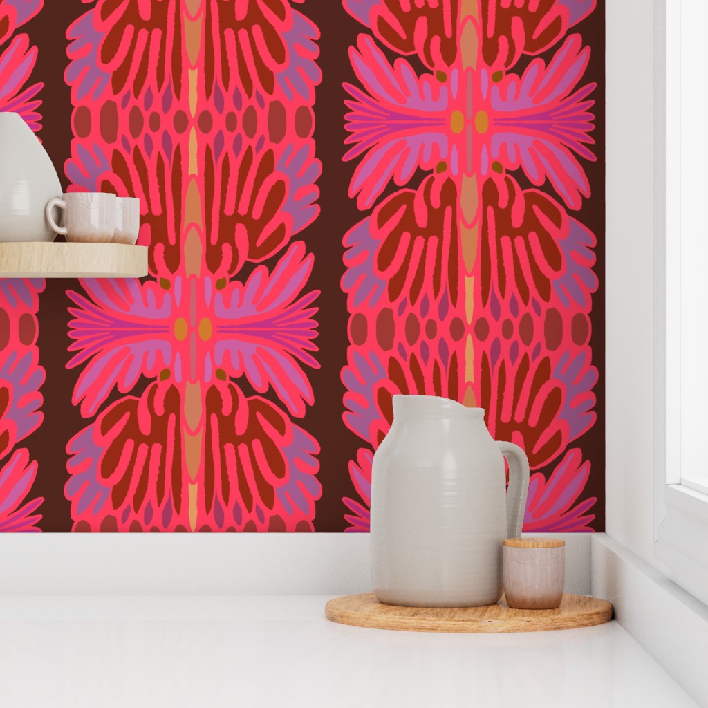 A styled interior scene showing a bold mid-century modern wallpaper with a pink, red, and brown floral pattern on a white shelf and countertop, alongside a ceramic pitcher, cup, and small tray. Designed by artist Leila Simon Hayes.