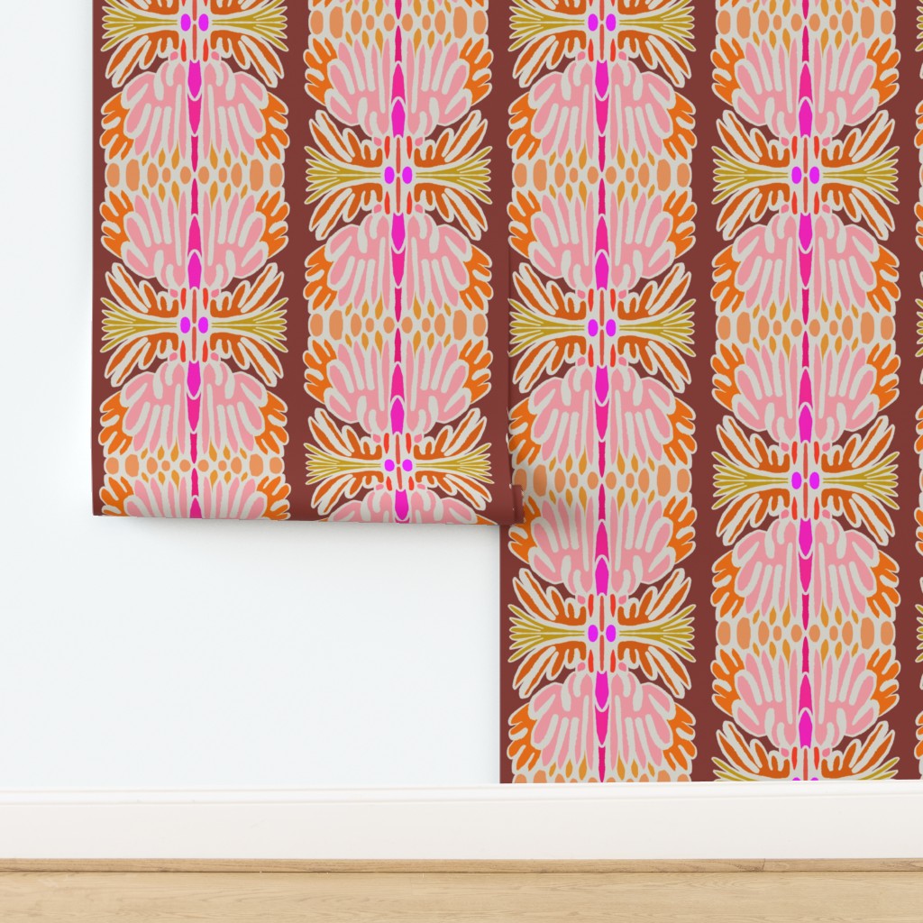 A roll of wallpaper with a retro vertical pattern in pink, orange, yellow, and brown, partially unrolled on a white wall above a light wood floor. Designed by artist Leila Simon Hayes.